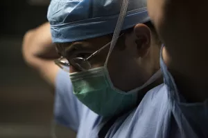 Abishnek Chatterjee, MD, MBA (Chief, Division of Plastic Surgery; Breast Surgical Oncologist; Plastic Surgeon; Breast Surgeon; Oncoplastic Specialist) putting on mask and dressing for surgery.