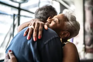 Senior couple happy and hugging at home.