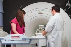 Stepahine Driver and Evan Kyranos, both MRI Technologists, looking over and setting up MRI machine at MelroseWakefield Hospital.